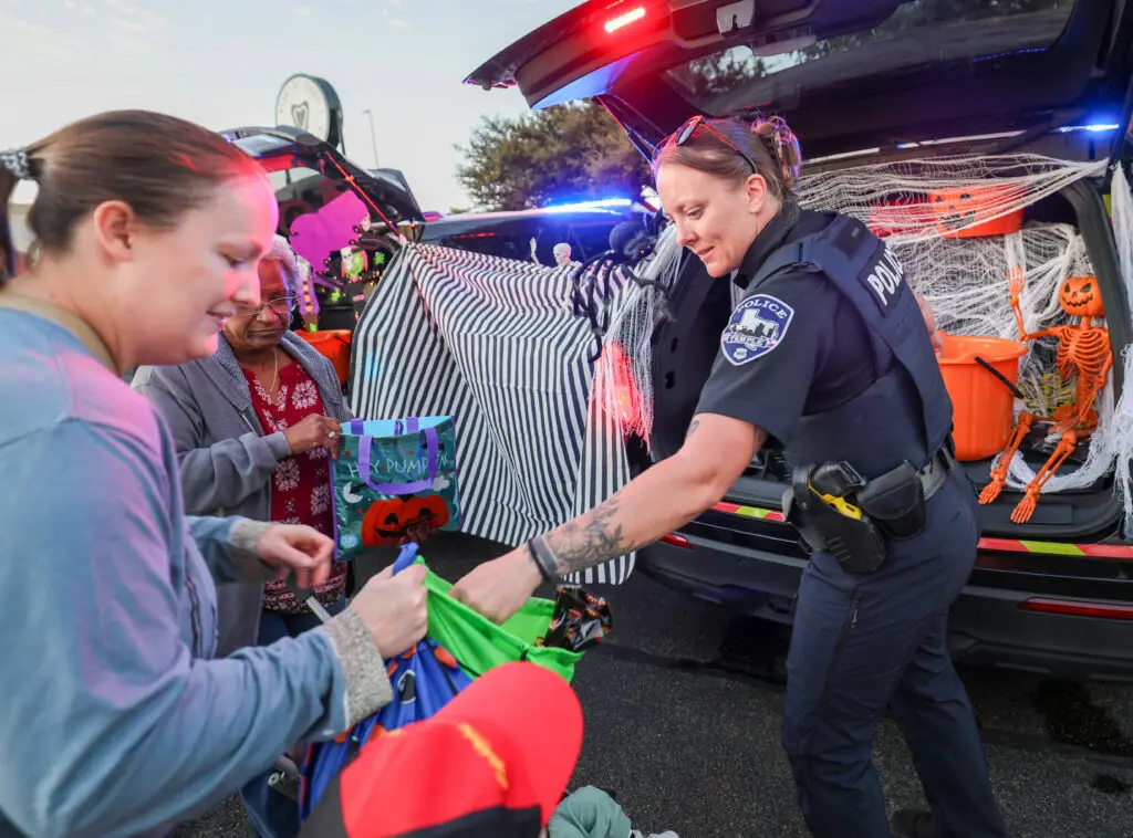 Temple police officer hands out candy at the 2026 Carlson Cares Trunk or Treat